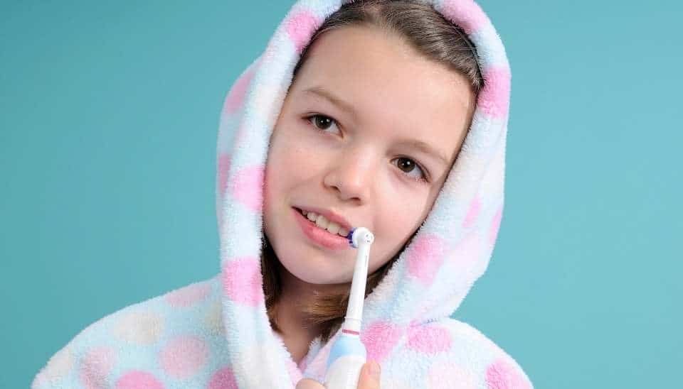 Young girl holding an electric toothbrush