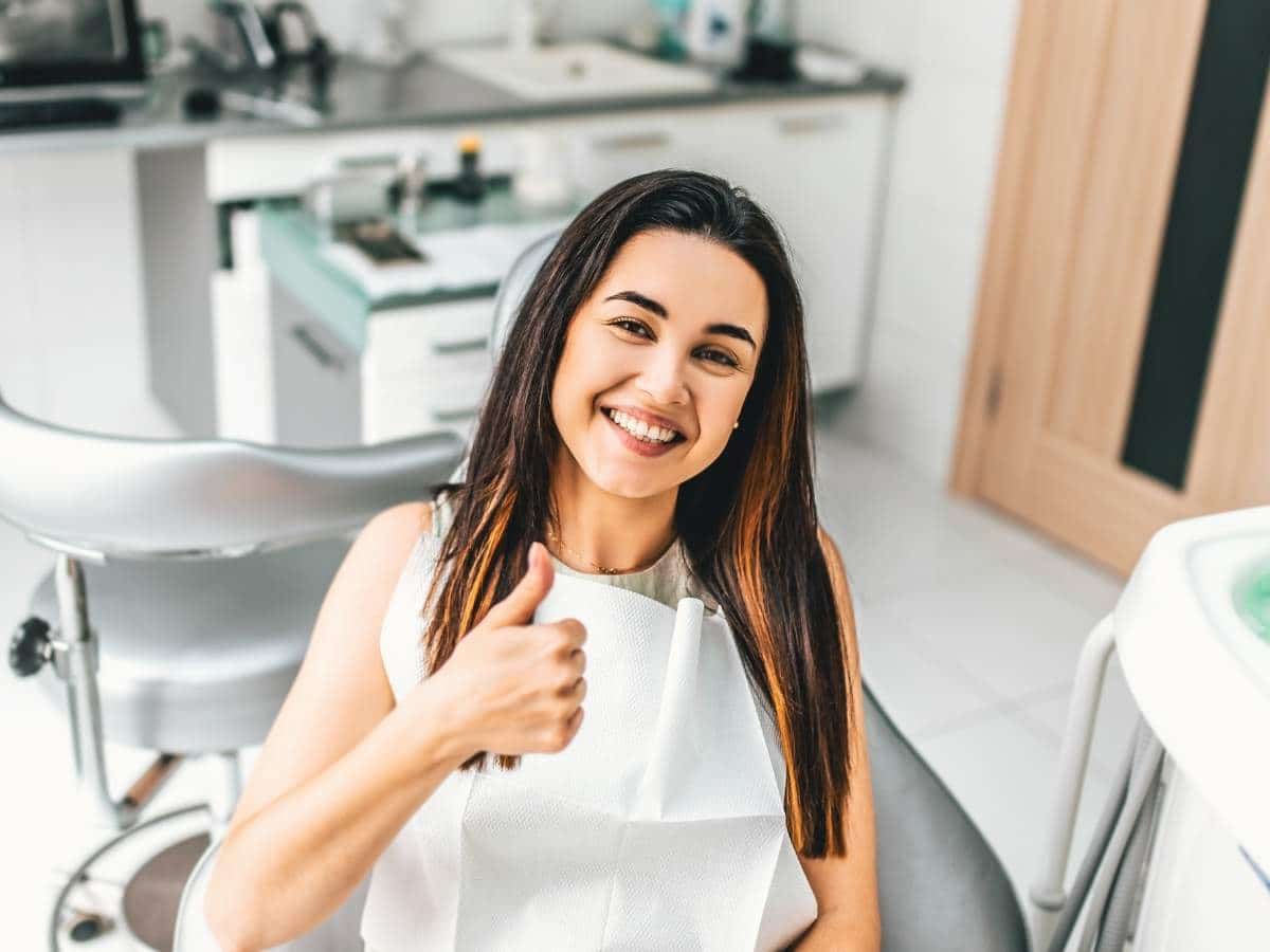 Happy woman with thumbs up before root canal treatment