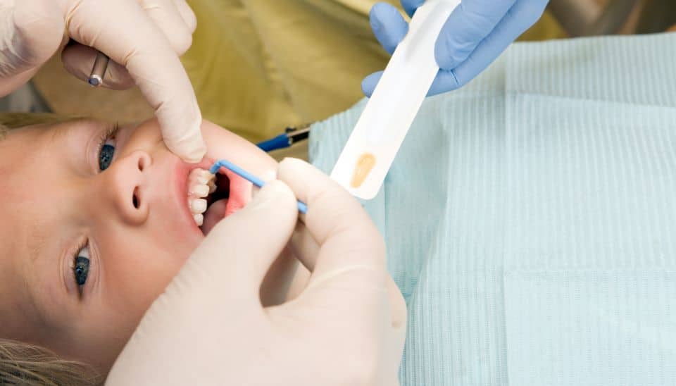 Young dental patient receiving fluoride treatment