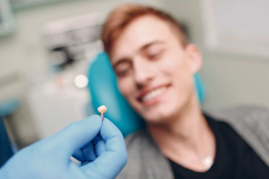 Dentist showing a patient a dental impant